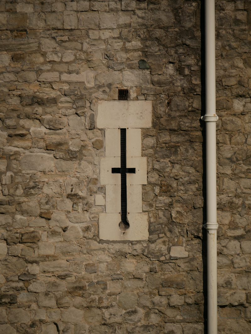 Cross-shaped arrow slit in a stone wall