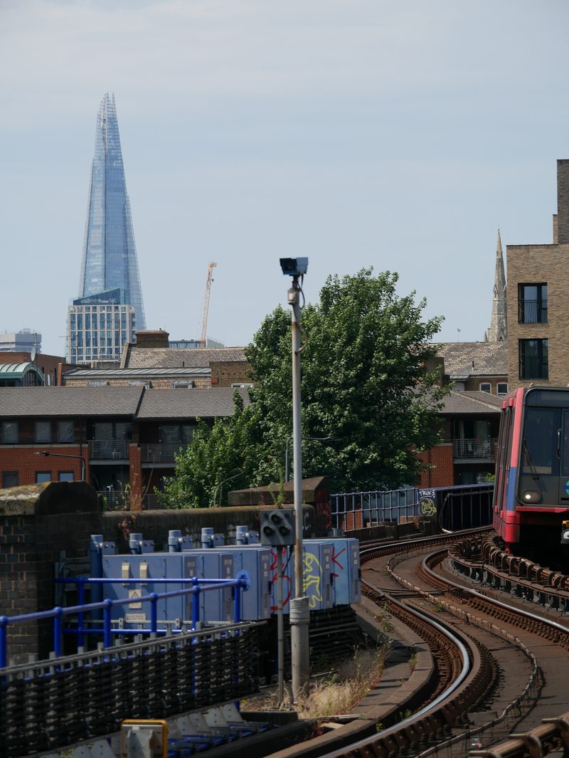 The Shard beyond rooftops, with a train